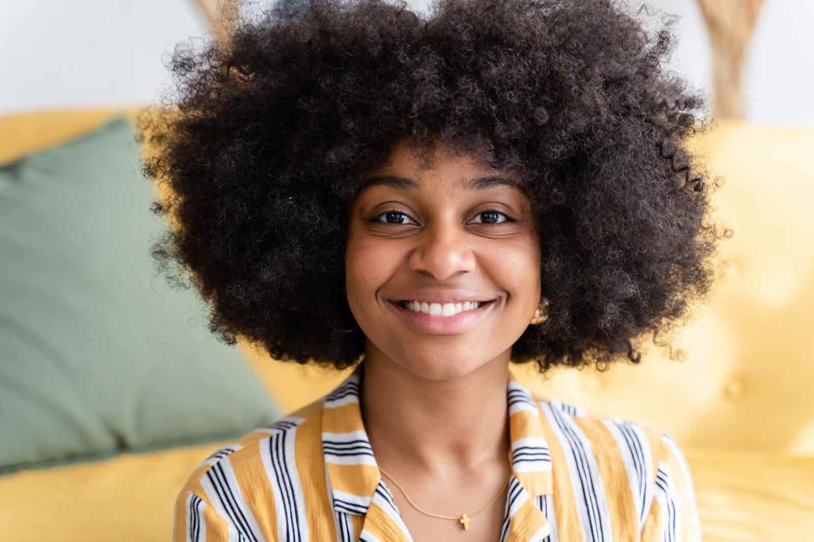 Cheerful black woman with curly hair looking confidently into the camera about her life choices.
