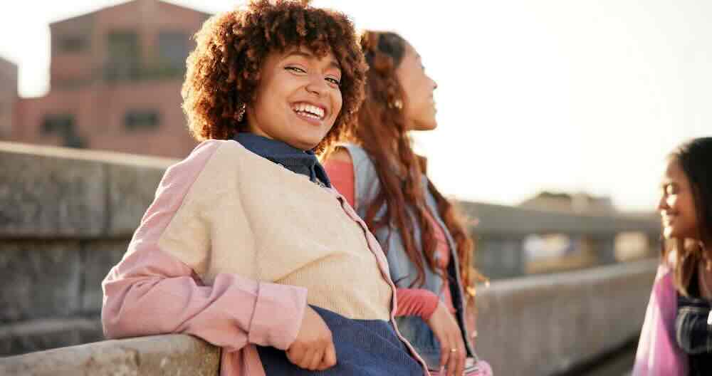 Fashionable friends sitting outdoors after visiting a caring center for women that explained, “What are the choices for an unplanned pregnancy?”