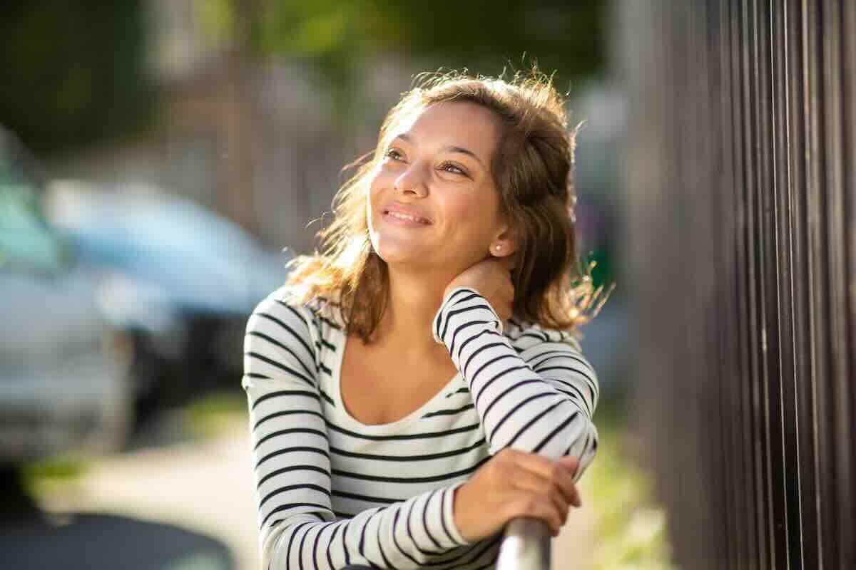 Woman in a striped shirt wondering why self care is important for women as part of all women’s healthcare.