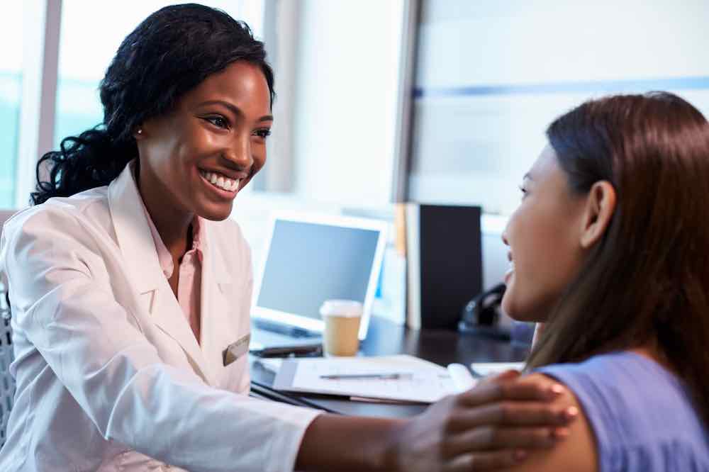 Doctor wearing white coat, ready to discuss early signs of pregnancy.
