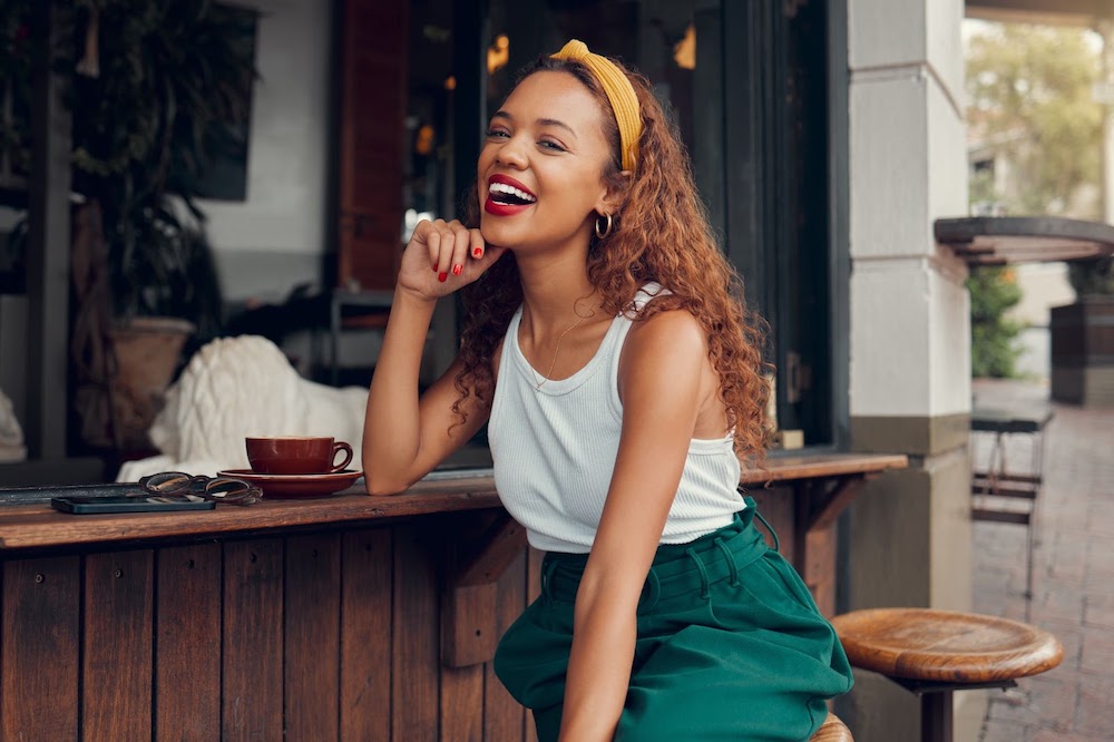 Woman in a coffee shop, feeling great about her women’s care