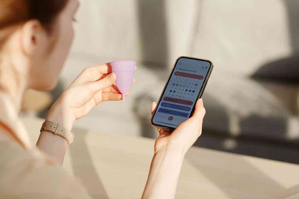 Woman looking at a period tracker app.
