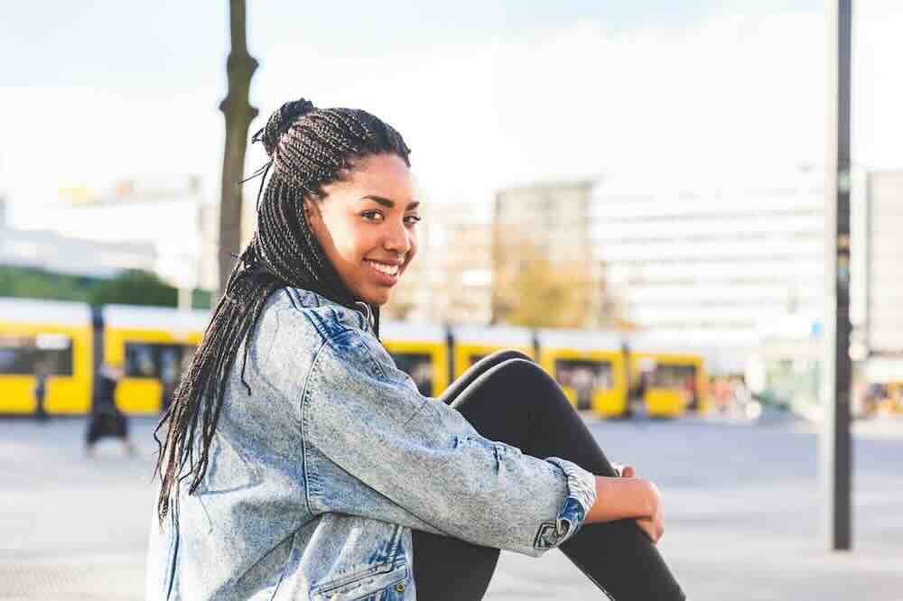 Seated woman with braids in a jean jacket who knows the answer to “how long do STD results take.”