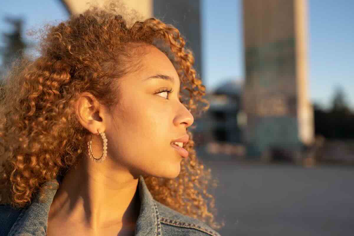 Woman with curly hair looking to the side and asking what’s the most likely STD to get?