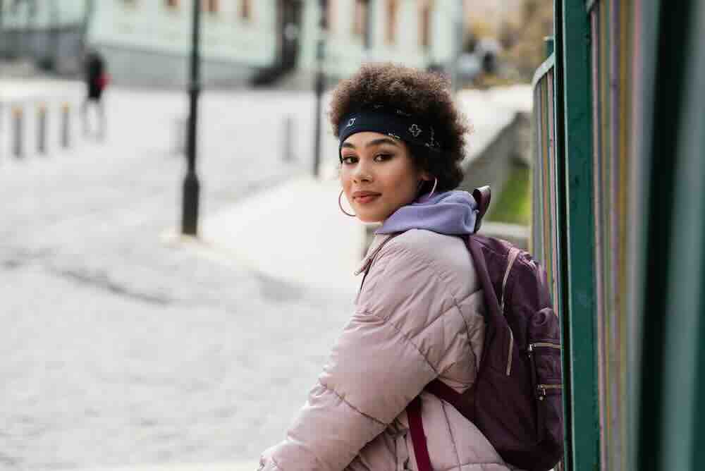 Woman with a puffy pink jacket asking “what are common symptoms of STDs?”